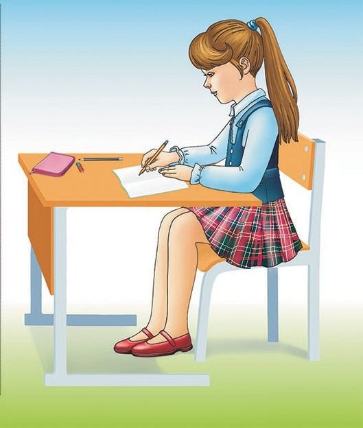Девочка правильно сидит за столом во время письма